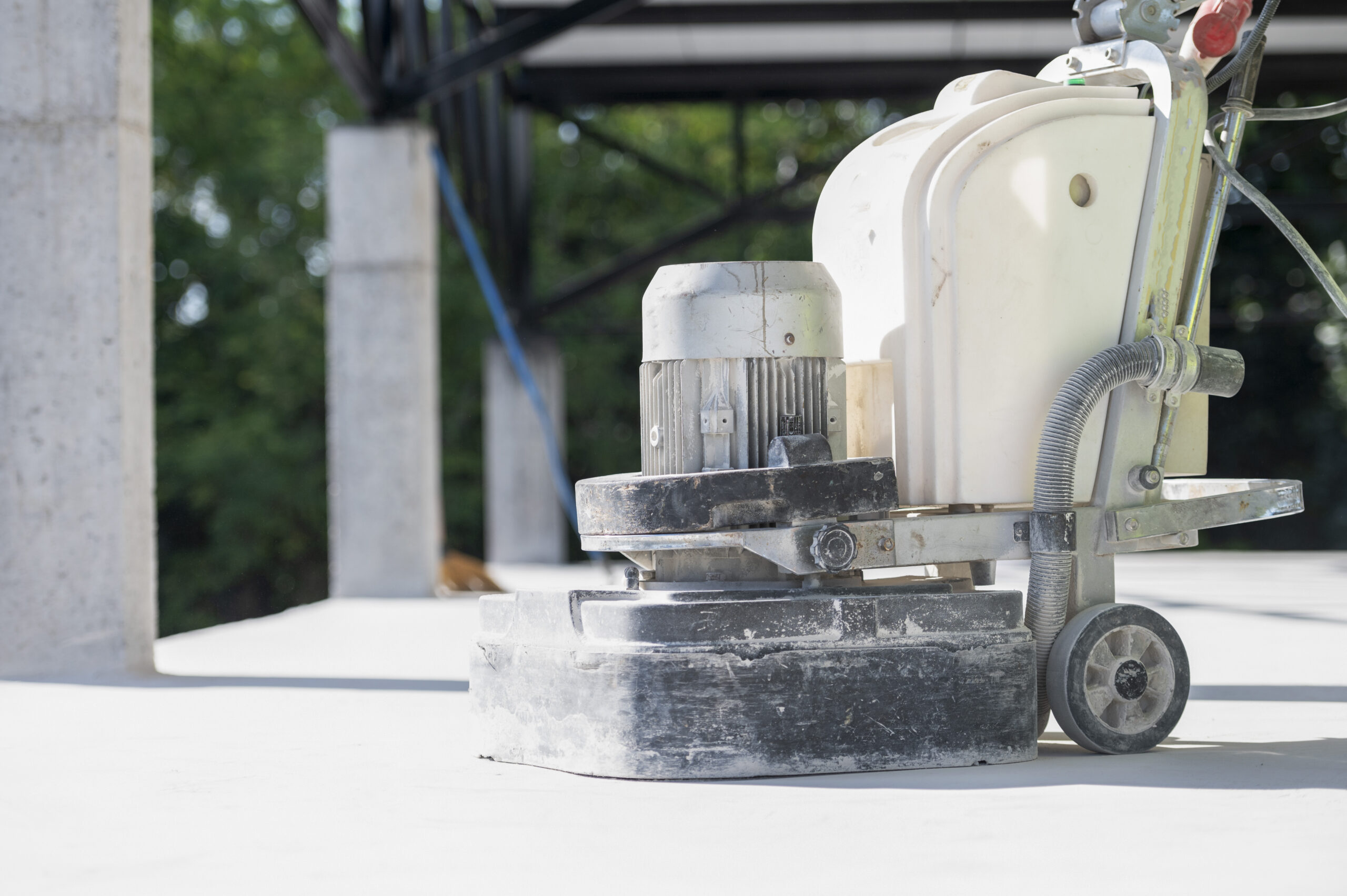 Construction workers use a machine to polish and finish surfaces